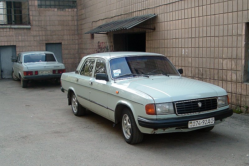 Светлая Волга ГАЗ-31029 у кирпичного дома