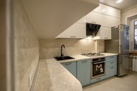 Столешница и стеновая панель выполнены в едином оттенке "Королевский Опал", органично перекликающимся с общим дизайном кухни