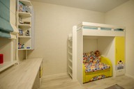 Яркие акценты в виде желтых фасадов, подушек, обивки дивана добавляют детской комнате уюта и стиля
