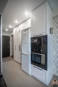 Распашной шкаф со встроенной бытовой техникой и  холодильник в коридоре