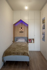 Распашной шкаф в зоне отдыха высокий, в потолок, с достаточным количеством зон хранения и оригинальной подсвеченной нишей над кроватью