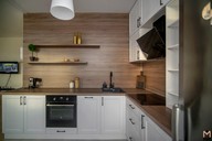 Белая кухня вид сбоку: открытые полки, нижние модули