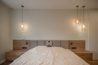 Изголовье двуспальной кровати изготовлено из велюра и гармонично вписывается в интерьер