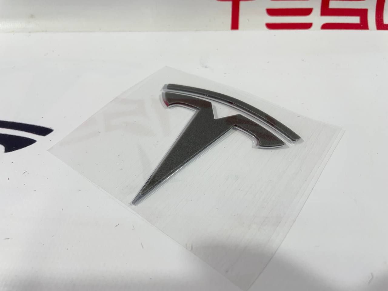 Эмблема "T" капота Tesla Model 3 1 поколение 2019, 1494949-00-A - фото №1