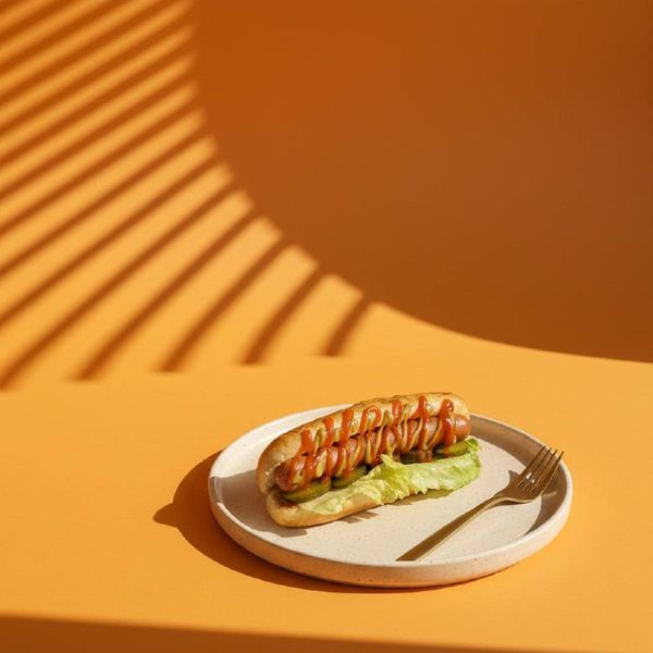 Креативная фуд-съемка хот-дога с жесткими тенями. Трендовый визуальный контент для социальных сетей фаст-фуда