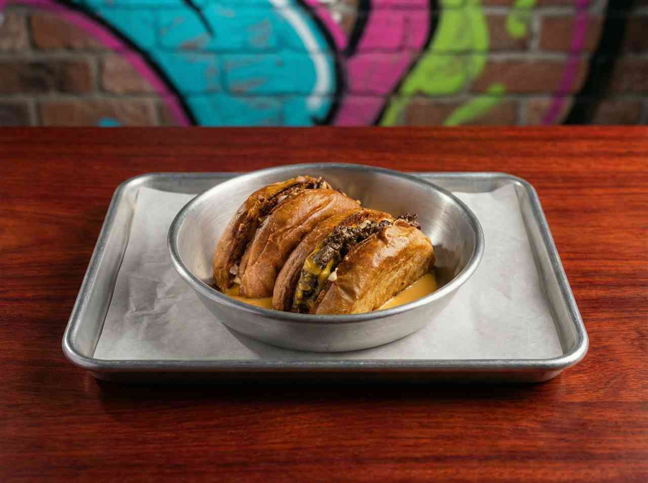 Аппетитная фуд-фотография двух сытных хот-догов в металлической посуде. Съемка американской уличной кухни для доставки