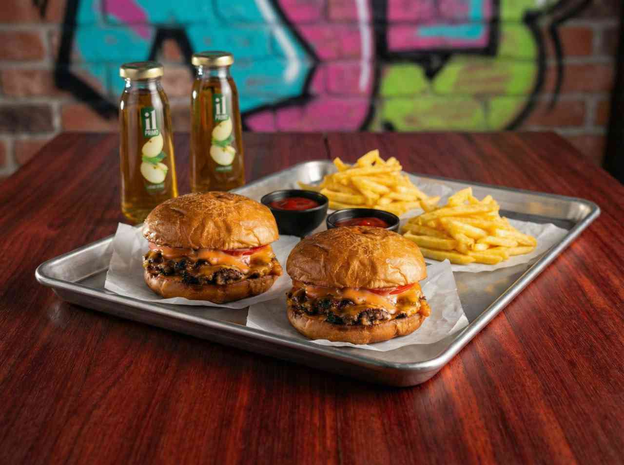 Масштабная фуд-съемка стрит-фуд меню: два бургера, фри и напитки. Единый дерзкий стиль с граффити для бренда уличной еды