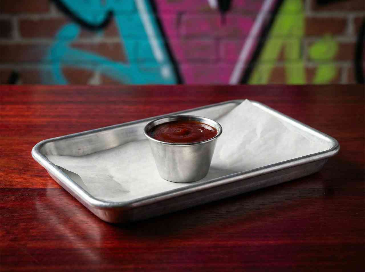 Макро-фотография томатного соуса в металлической соуснице. Детальная съемка дополнений к блюдам для меню ресторана