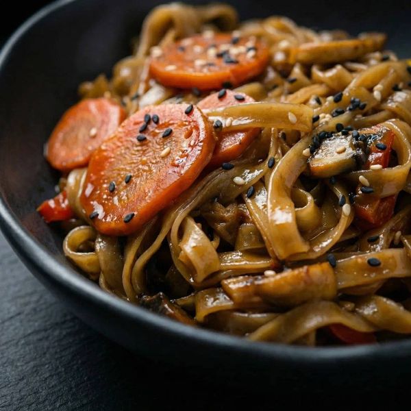 Макро-снимок лапши вок с кунжутом. Эмоциональная close-up фотография для привлечения внимания