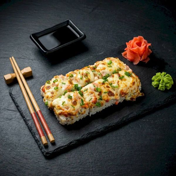 Запеченные роллы на темном камне. Предметная фуд-фотография японской кухни для агрегаторов доставки