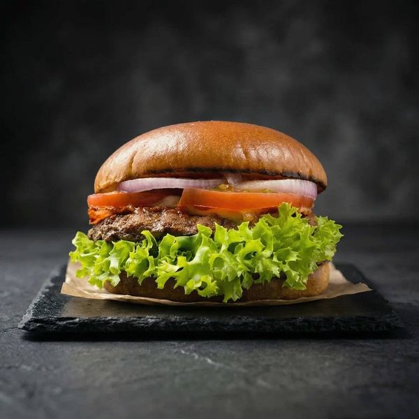 Сочный бургер на темном фоне. Аппетитная фуд-съемка стрит-фуда для мульти-форматного меню