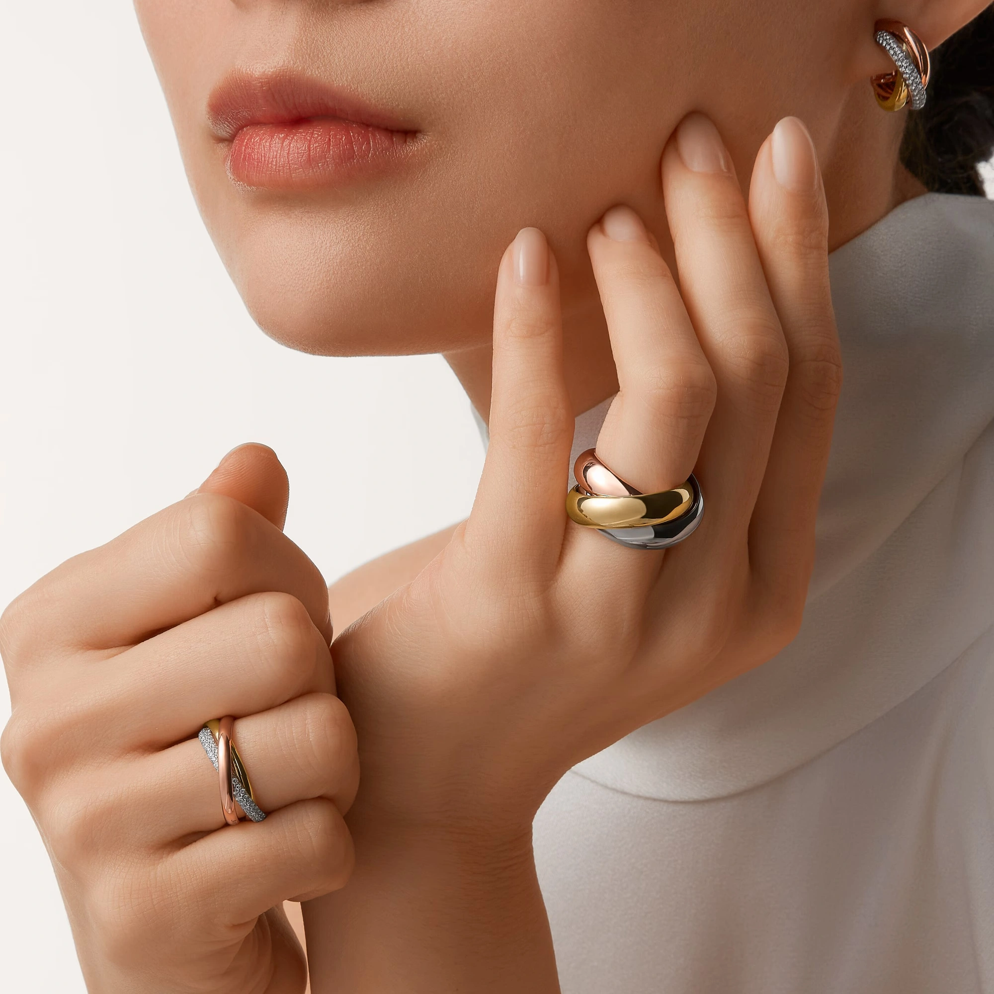 Model wearing a tricolour Cartier Trinity ring and matching jewellery.