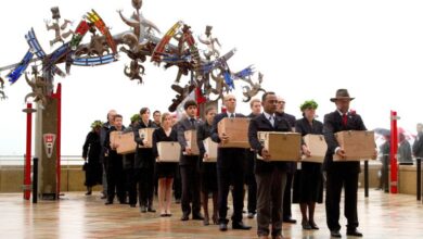 A Repatriation Team carry 20 Maori mummified tattooed heads (Toi Moko) that were taken to Europe in the 1700s and 1800s into the Marae during a Maori welcome ceremony at Te Papa Museum in Wellington on January 27, 2012. The tattooed heads were handed over by French officials at the Quai Branly Museum in Paris after a four-year political struggle. The Maori heads were once warriors that tattooed their faces with elaborate geometric designs to show their rank and were an object of fascination for European explorers who collected and traded them from the 18th century ownwards. AFP PHOTO / MARTY MELVILLE (Photo by Marty Melville / AFP)