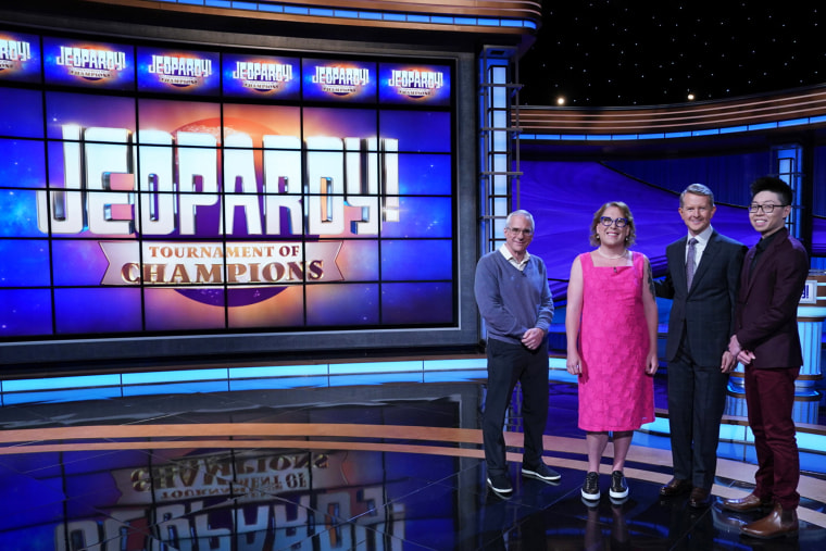 Contestants Sam Buttrey, Amy Schneider and Andrew He stand with Jeopardy! host Ken Jennings.