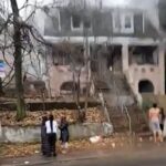 People stand outside a house fire Friday morning in New York City's Staten Island