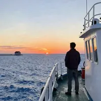 Muž u moře při západu slunce