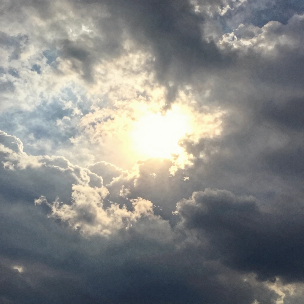 A dramatic sky clearing after a storm, with dark clouds part...