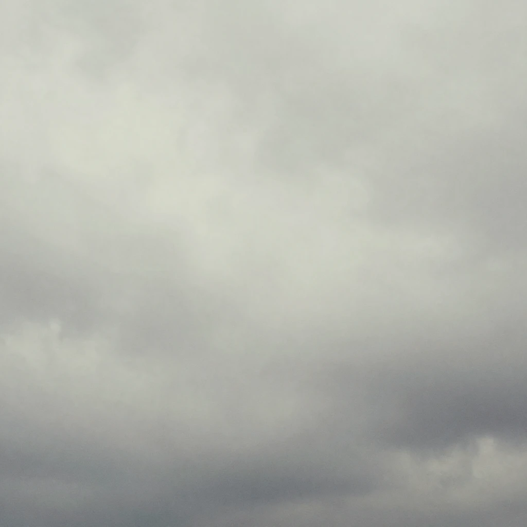 A wide shot of a grey, overcast sky with soft, diffused ligh...