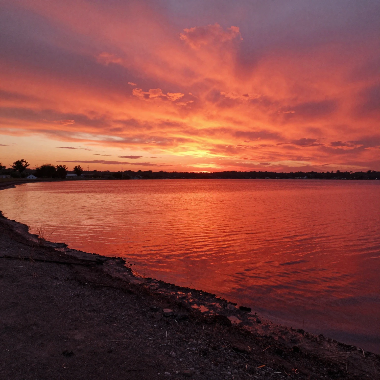 A vibrant red lake with dark, almost black shores, reflectin...