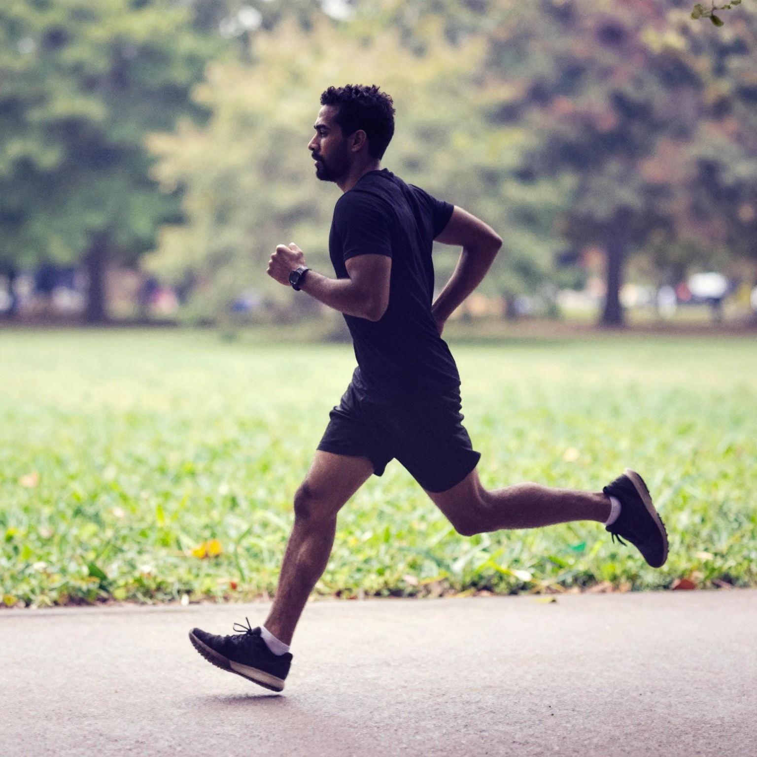 Dynamic silhouette of a man running in a park, vibrant water...