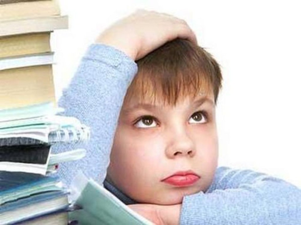 Мальчик. Младший школьник заваленный учебниками