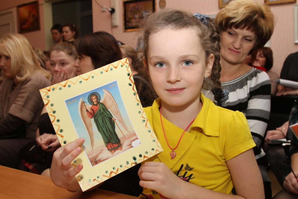 Девочка держит рисунок