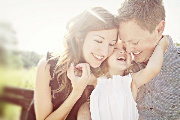 Родители обнимают дочь