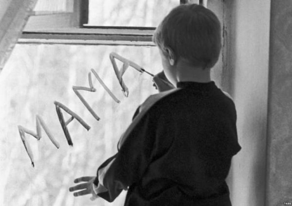 Мальчик пишет на стекле мама