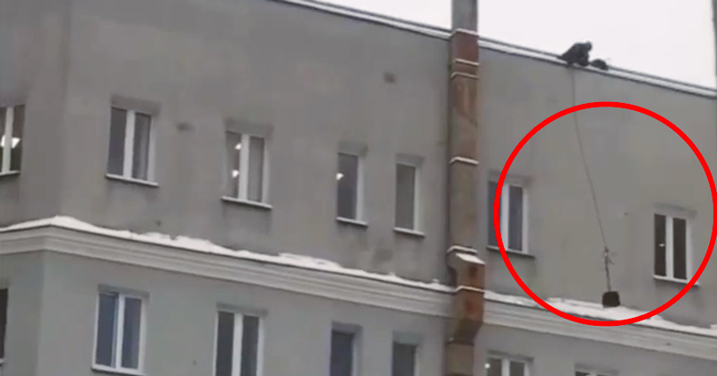 Коммунальщик повесил лопату на веревку и так попытался убрать снег с карниза