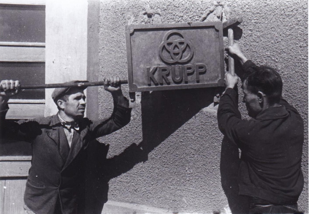 Рабочие срывают вывеску Круппа, которая была повешена на Краматорском заводе им. Сталина в дни немецкой оккупации, г. Краматорск. 1943.