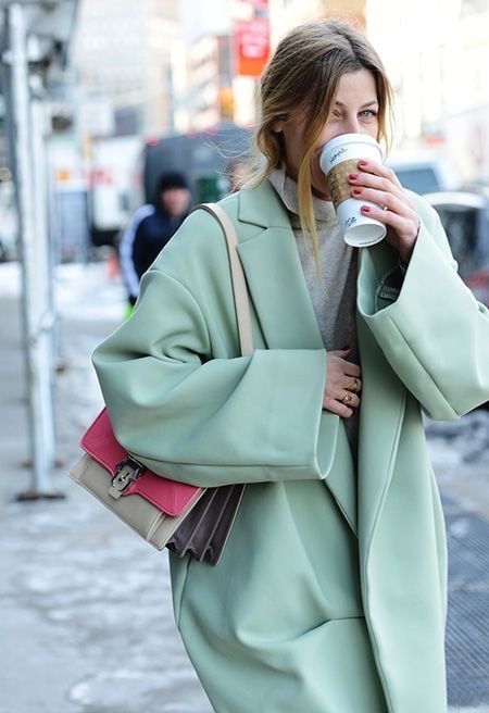 Женское светло зеленое пальто с розовой сумкой 
