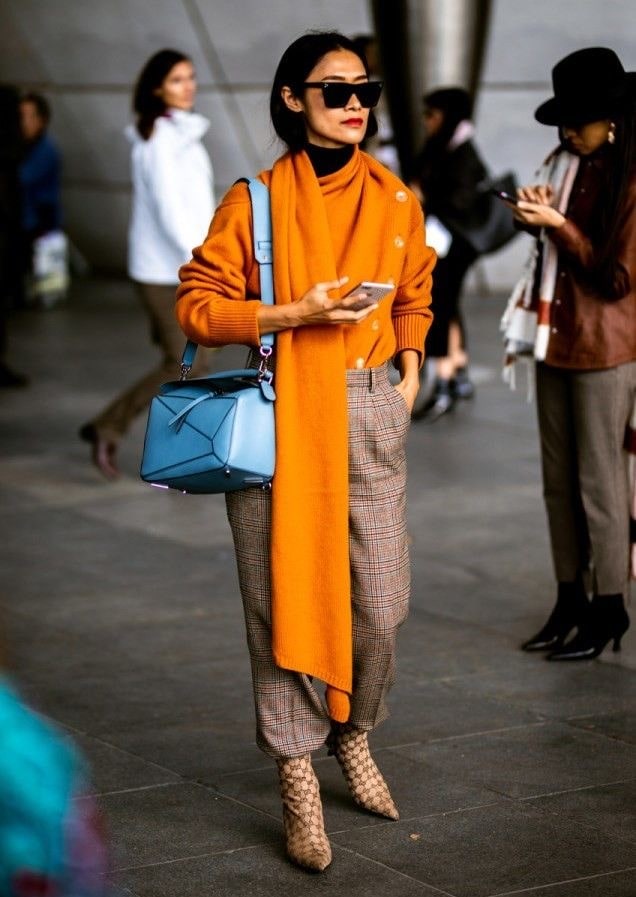 Женская кофта оранжевого цвета с бежевыми брюками в клетку 
