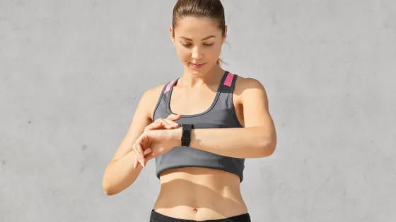 fit-woman-looks-attentively-smartwatch-goes-sport-has-healthy-body-controls-her-pulse