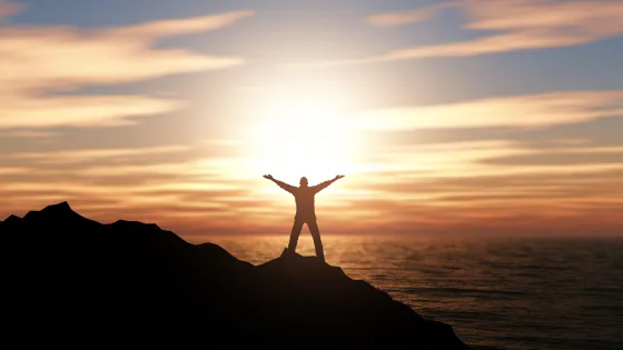 3d-silhouette-man-with-arms-raised-against-sunset-ocean-landscape