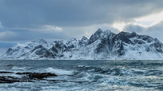 beautiful-shot-sea-waves-with-snowy-mountain-background_181624-36598