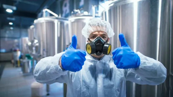 professional-technologist-expert-protective-white-uniform-with-hairnet-mask-gloves-holding-both-thumbs-up_342744-1181