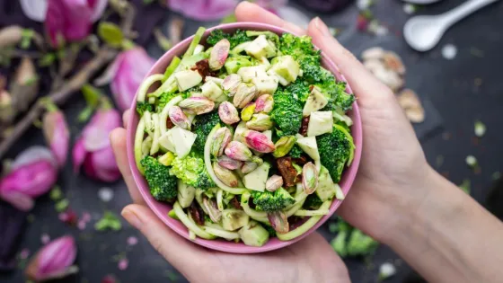 top-view-person-holding-bowl-delicious-vegan-salad_181624-35155