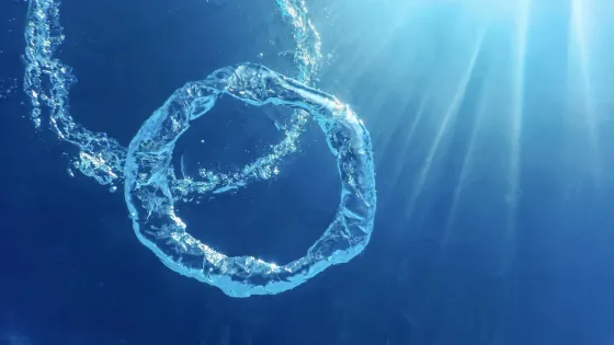 bubble-ring-ascends-towards-sun-underwater_559531-10478