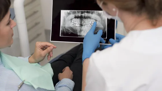 female-patient-looking-radiography-her-teeth-with-dentist