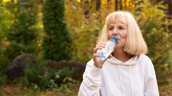 older-woman-drinking-water-outdoors