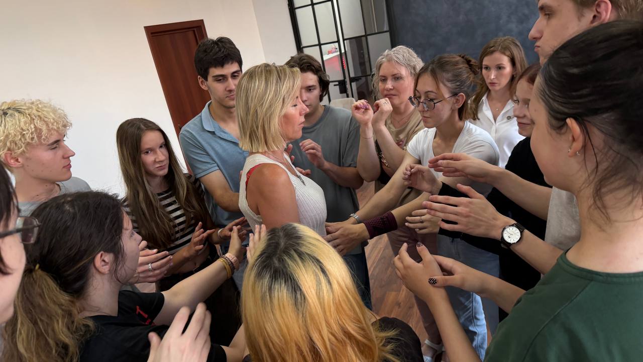 Участники группового занятия работают в тесном кругу, взаимодействуя жестами.