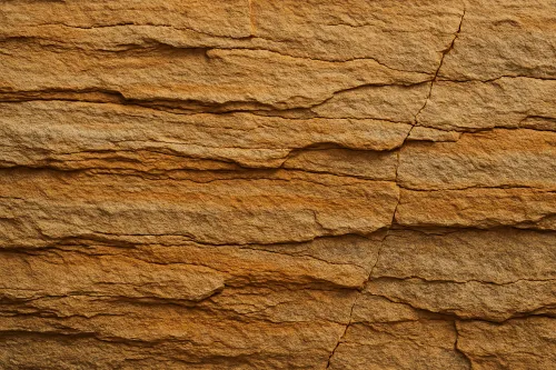 Close-up view of a layered rock surface exhibiting warm brown hues