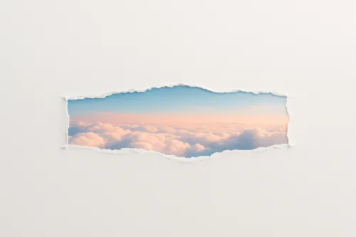 Cloudy sky with soft hues against a white wall