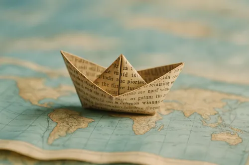 Barco de papel sobre el fondo de un antiguo mapa mundial