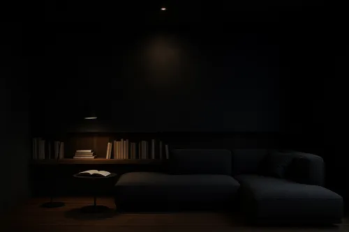 Dark interior with a sofa, table, and reading lamp
