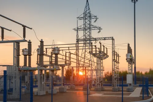 Substation with structures and high-voltage wires at sunset
