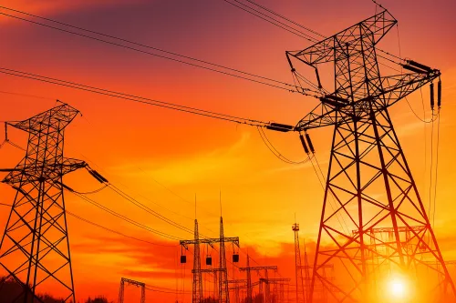 Power lines and towers against a vibrant sunset