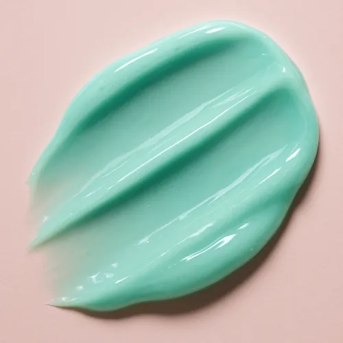 Smooth texture of light green cream on a neutral background
