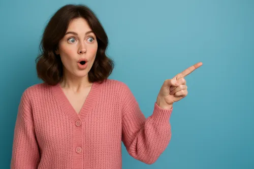 Woman in a pink sweater pointing with her finger, showing a surprised expression