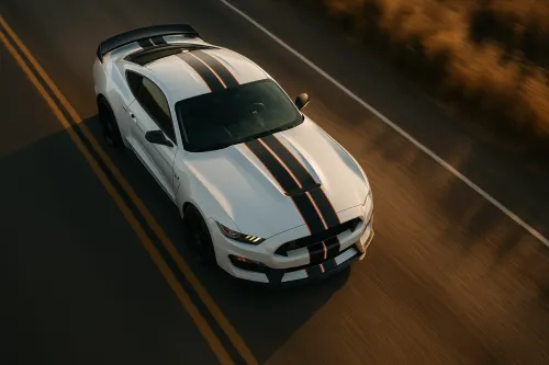 White sports car with black stripes on an open road